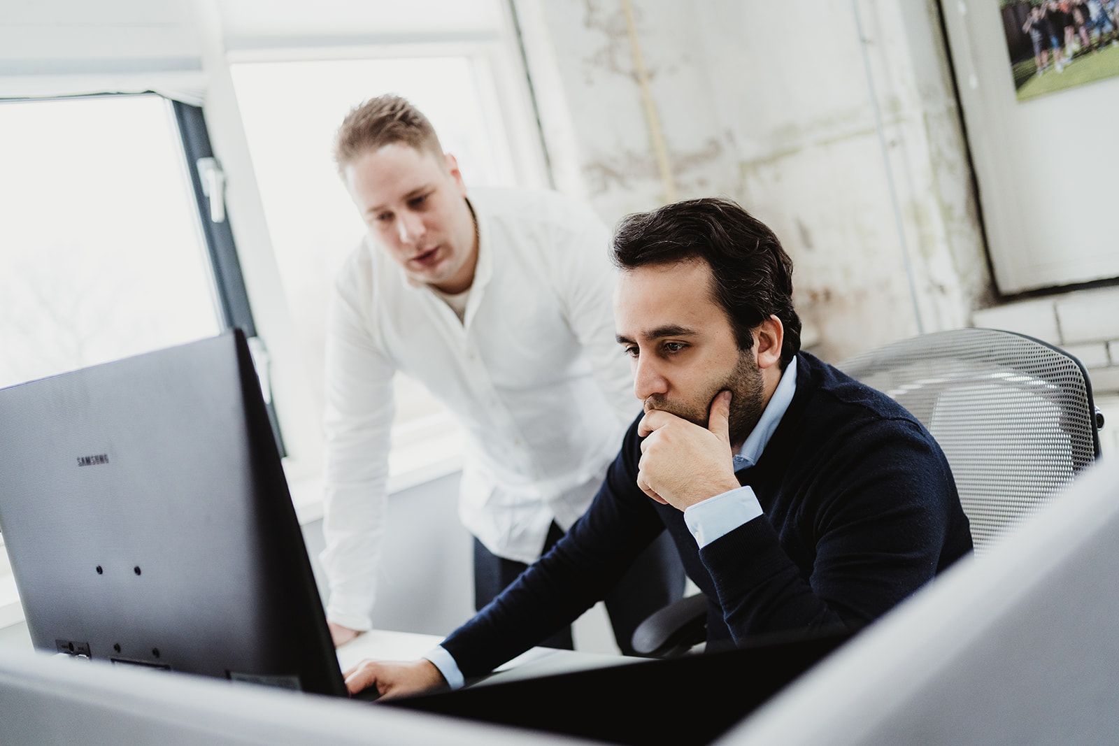Close-up van een professional die op een toetsenbord typt naast een laptop in een moderne werkruimte, wat productiviteit, technologie en digitale werkomgevingen symboliseert.